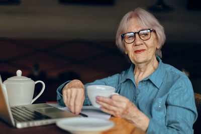 Smiling senior woman sitting at cafe