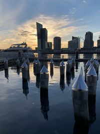 Scenic view of river by buildings against sky during sunset