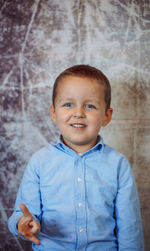 Portrait of boy standing against trees