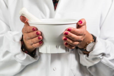 Midsection of doctor holding mortar and pestle