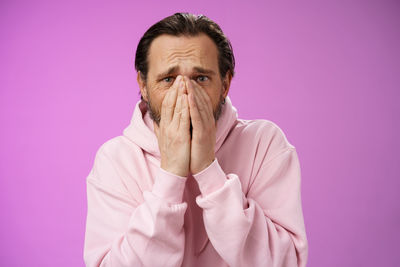 Portrait of man against pink background