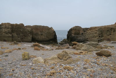 Rocks on beach against clear sky