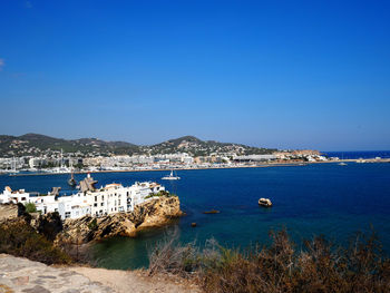 City at coastline against clear blue sky