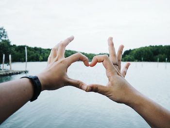 Midsection of man with hands against sky