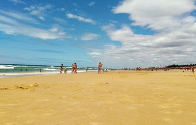People at beach against sky