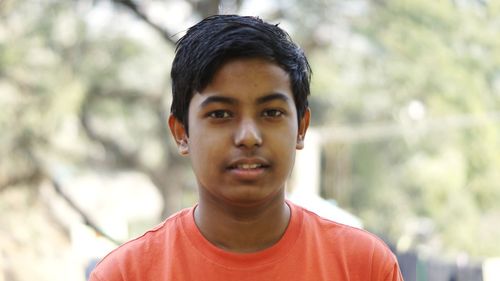 Close-up portrait of teenage boy standing outdoors