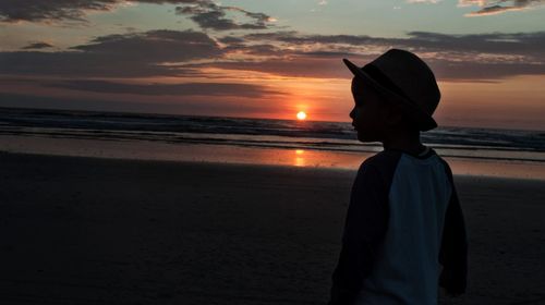Man standing on beach at sunset