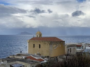 Lighthouse by sea against sky