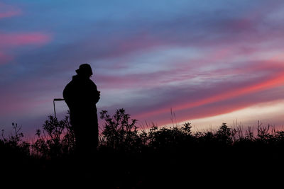 Silhouette man looking at sunset