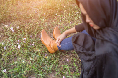 High angle view of woman wearing headscarf sitting on grass