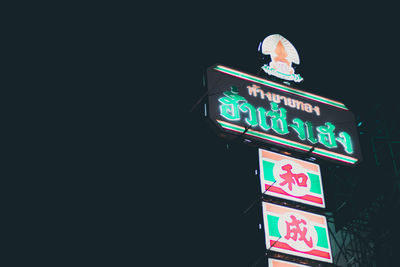 Low angle view of information sign at night