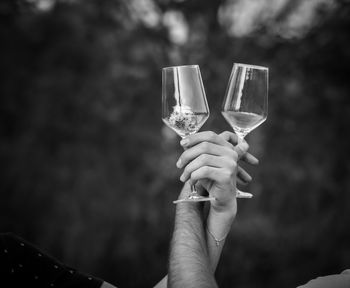 Black and white photo, tow hands with empty wine glasses