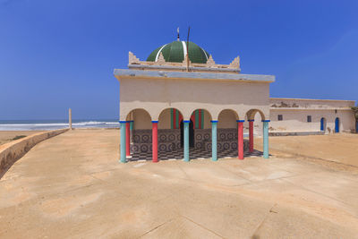 Built structure on beach against clear blue sky