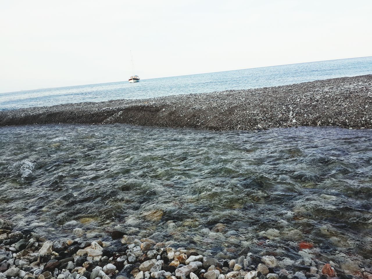 sea, water, clear sky, copy space, beach, horizon over water, transportation, shore, tranquil scene, nature, tranquility, scenics, beauty in nature, sky, day, mode of transport, outdoors, nautical vessel, wave, sand