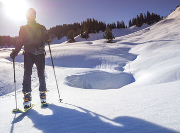 Man skiing on snowcapped mountain during sunny day