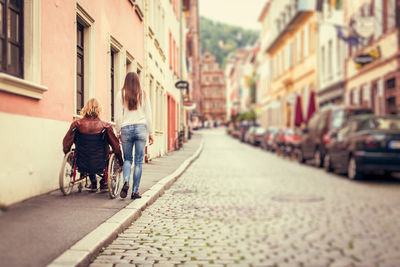 Rear view of couple walking on street in city