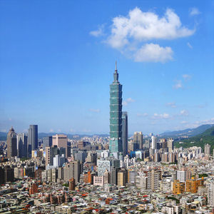 Aerial view of buildings in city against cloudy sky