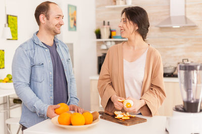 Man and woman standing by fruits