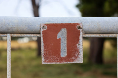 Close-up of sign on metal fence