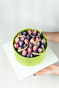 Cropped hand of woman holding food in bowl on white background