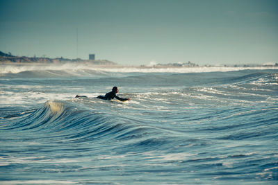 Man surfing in sea against sky