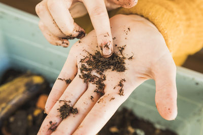 Woman pointing at worm with dirt on hand