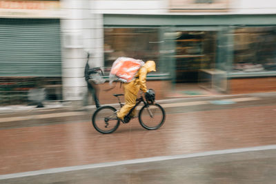 Man riding bicycle on road in city