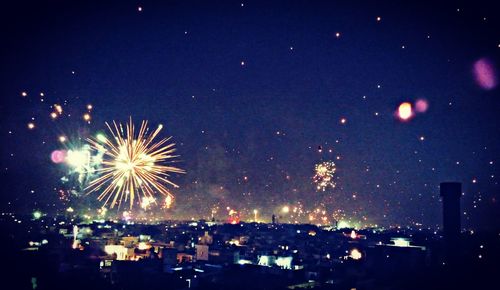 Firework display against sky at night