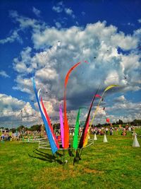 Rainbow over grassy field against cloudy sky