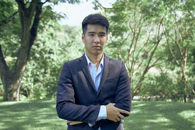 Portrait of young man standing against plants