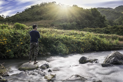 Rear view of man looking at waterfall