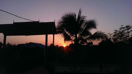 Silhouette palm trees against clear sky at sunset