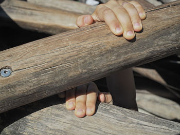 Cropped image of hands holding wood