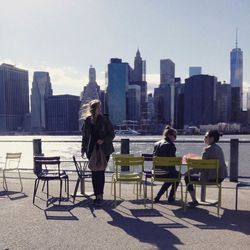 Full length of woman sitting on city street