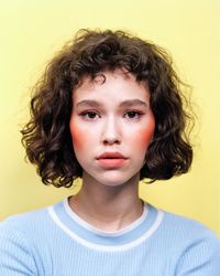 Portrait of woman against yellow background