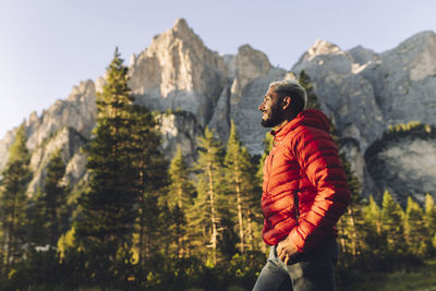 Smiling man standing in front of dolomites, italy