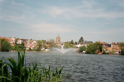 Fountain in city against sky