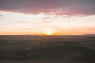 Scenic view of desert against sky during sunset