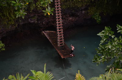 High angle view of man standing on pier over lake