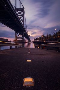 Bridge over river against sky at sunset