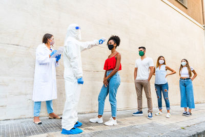 Group of people standing against the wall