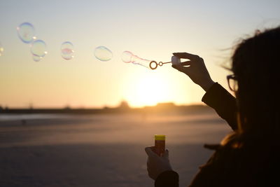 Close-up of woman playing with bubble wand