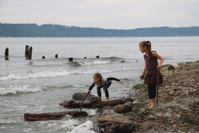 Two little girls playing at beach barefoot 