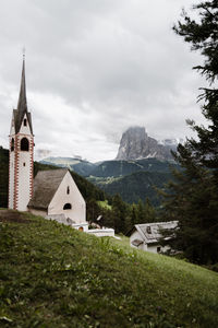 Buildings by mountain against sky