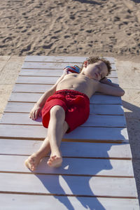 Child sunbathing lying on a pool lounger