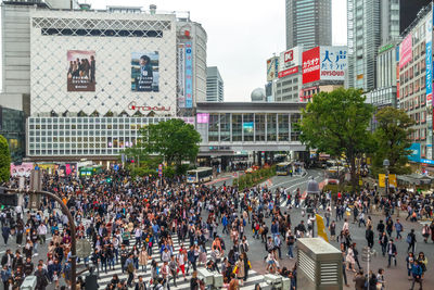 Crowd on city street against modern buildings