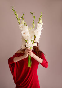 Midsection of woman holding gift against wall