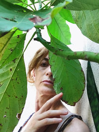 Portrait of young woman with leaves outdoors