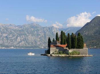 Scenic view of sea by buildings against sky