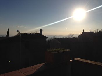 Silhouette buildings against sky at sunset